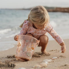 Child scooping sand with the Little Dutch Beach Bucket Ocean Dreams Pink