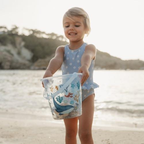 Child holding the Little Dutch Beach Bucket Ocean Dreams Blue at the beach