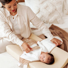 Parent dressing a baby on the Meyco Soft Sand terry changing pad cover