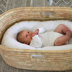 Baby in the Ko-Coon nesting pod inside a Moses basket