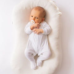 Baby lying in the Ko-Coon milky white nesting pod