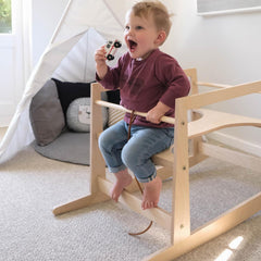Toddler riding the Ko-Coon rocker as a rocking horse